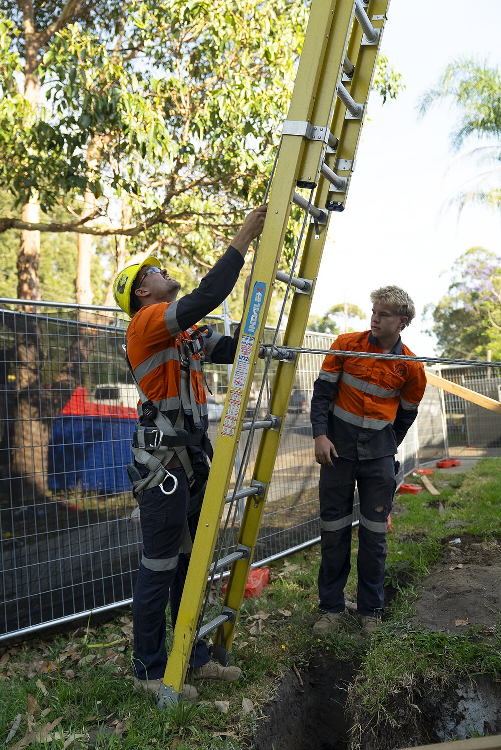 DM Electrical electrician working on a switchboard, branded DM hoodie